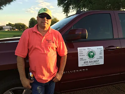Jim, the owner, standing beside a work truck with the company name on the door